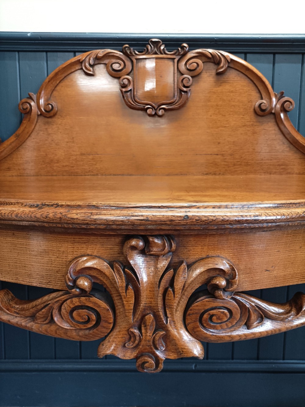 A carved mid-19th-century Victorian oak hall console table featuring scrolled cabriole legs, a central acanthus leaf apron, and a raised gallery back with a carved shield crest. View IX