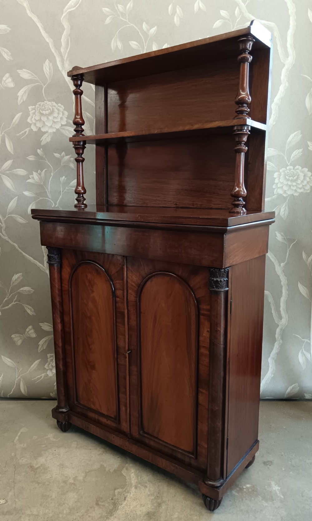 A Regency mahogany chiffonier featuring a two-tier open shelf superstructure above a two-door lower cabinet with arched panel doors and turned columns. View II