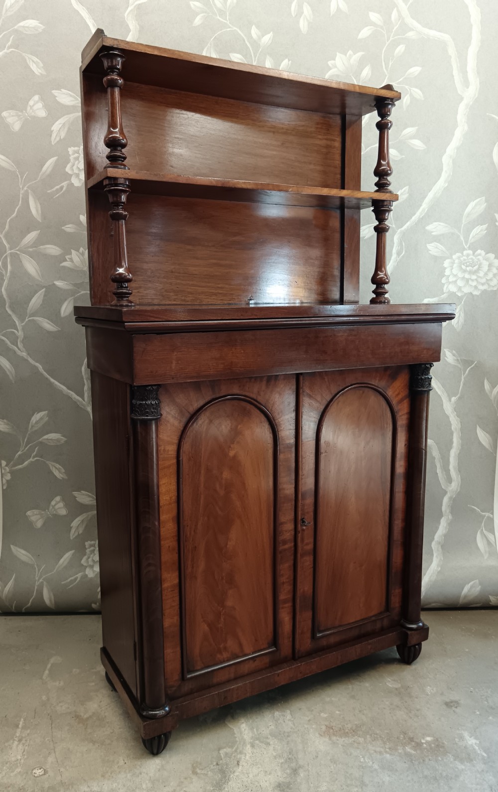 A Regency mahogany chiffonier featuring a two-tier open shelf superstructure above a two-door lower cabinet with arched panel doors and turned columns. View III