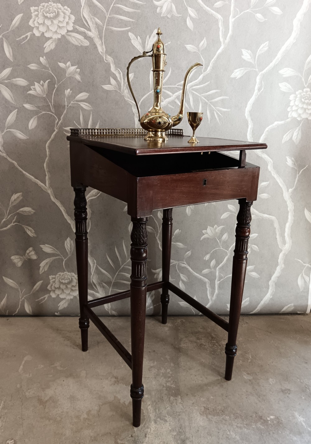 A dark mahogany Regency ladys writing desk featuring turned reeded legs, a single drawer with a keyhole escutcheon, a leather inset top, and a brass gallery along the rear edge. View II