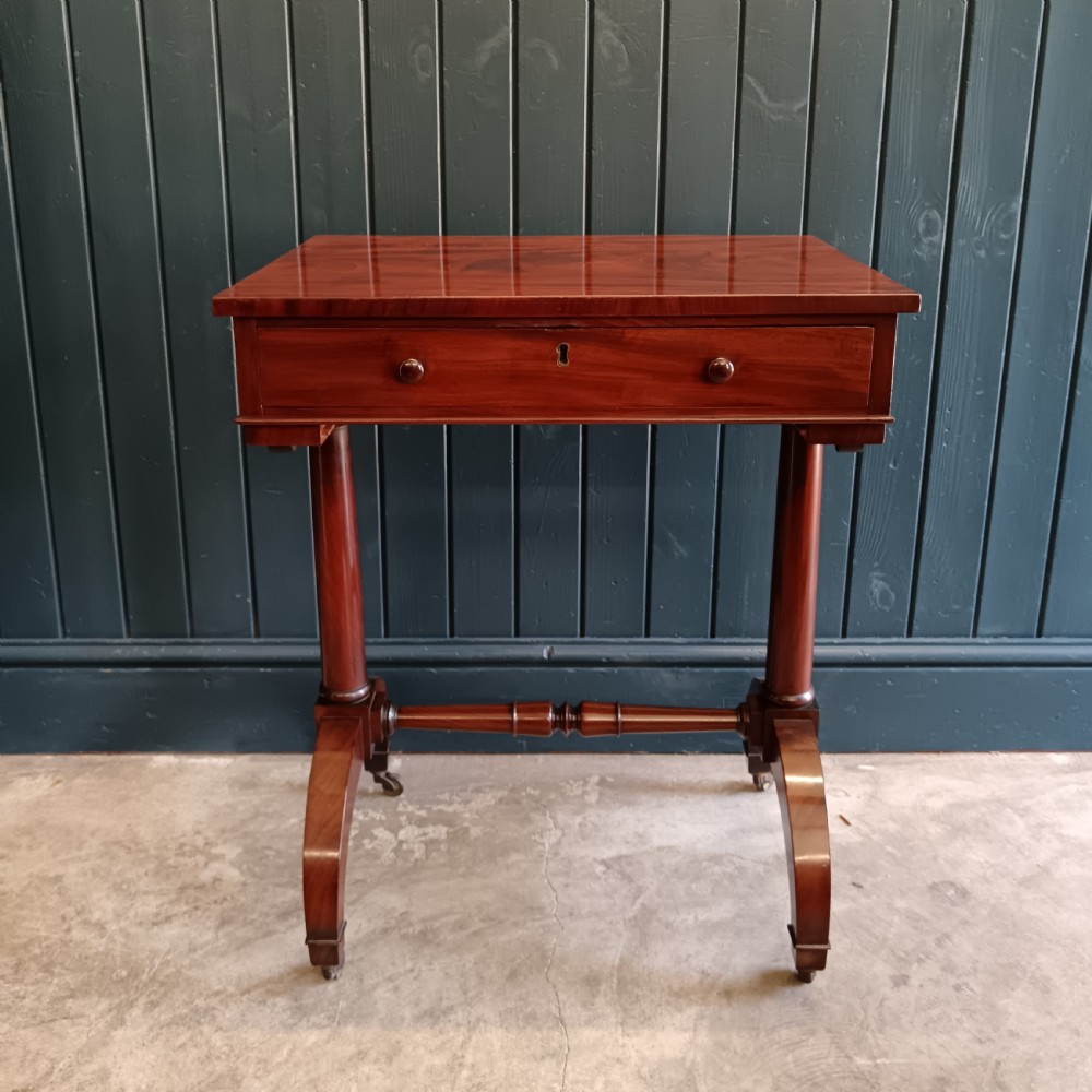 A nineteenth-century mahogany work table featuring a single drawer, a pleated fabric storage basket underneath, turned legs, and brass castors. View II