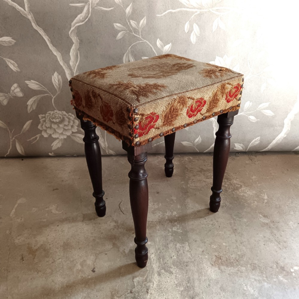 A rectangular Victorian mahogany stool featuring dark turned legs and a tapestry top with red floral rose motifs bordered by brass studs. View III