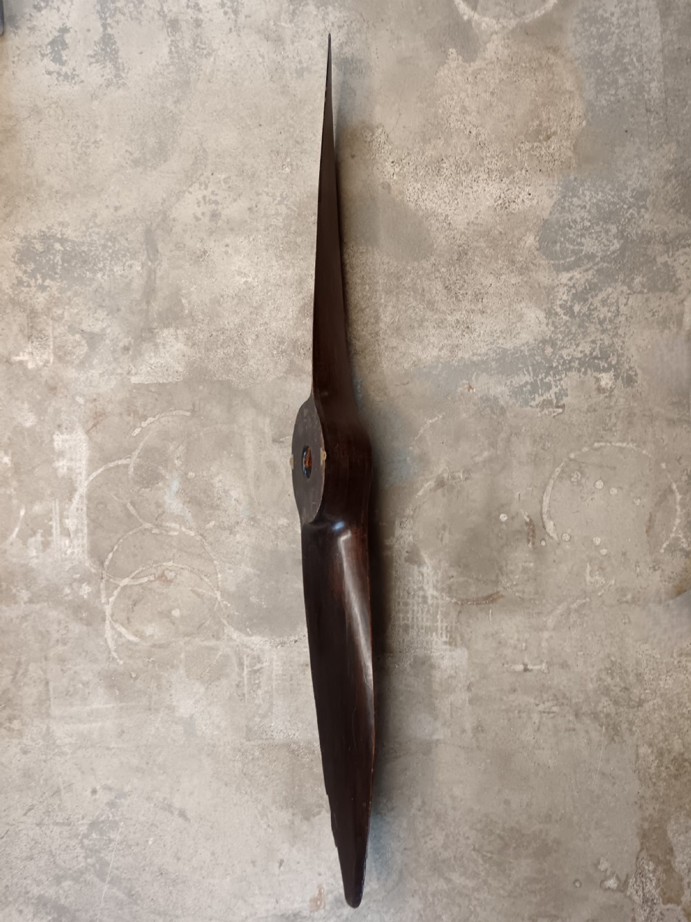 A carved two-blade dark mahogany timber aircraft propeller with a central mounting hole. View II