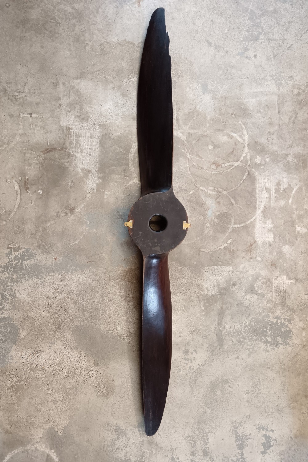 A carved two-blade dark mahogany timber aircraft propeller with a central mounting hole. View XVII
