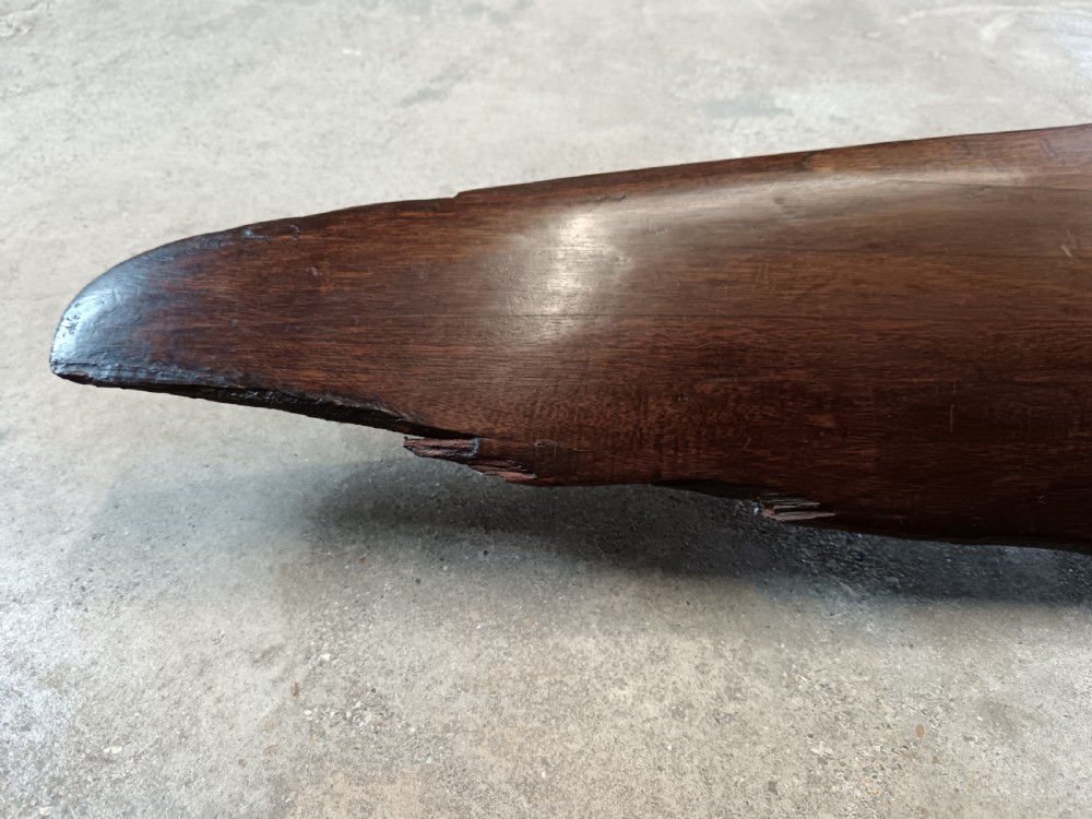 A carved two-blade dark mahogany timber aircraft propeller with a central mounting hole. View XI