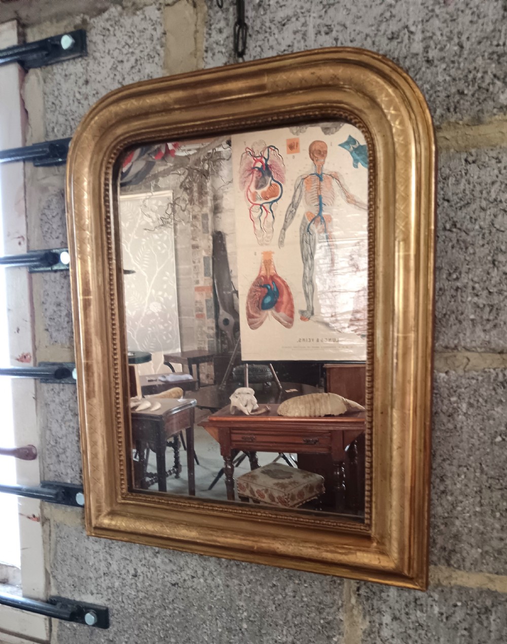 A 19th-century French arched wall mirror featuring a giltwood frame with rounded top corners and beaded inner trim.