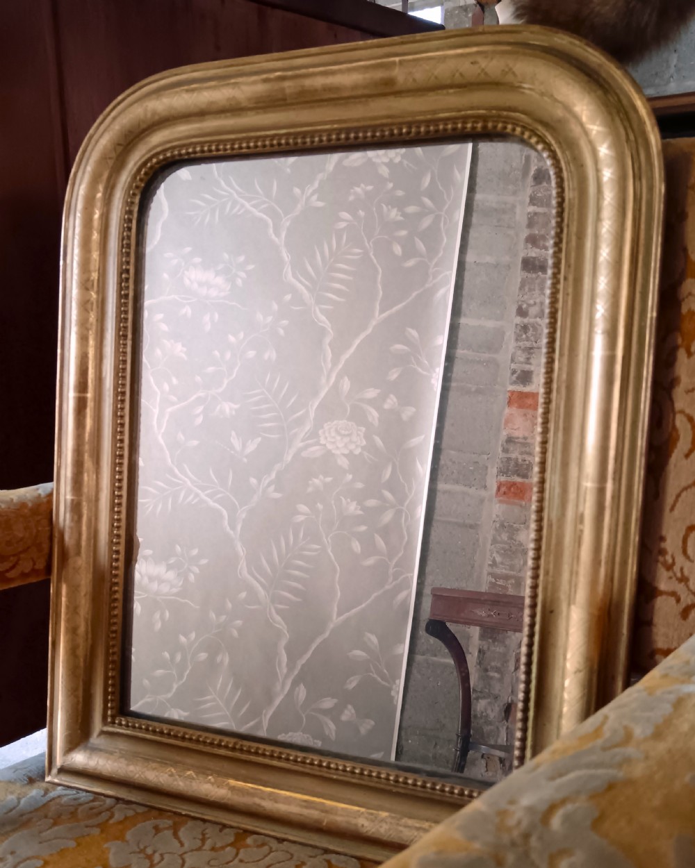 A 19th-century French arched wall mirror featuring a giltwood frame with rounded top corners and beaded inner trim. View X