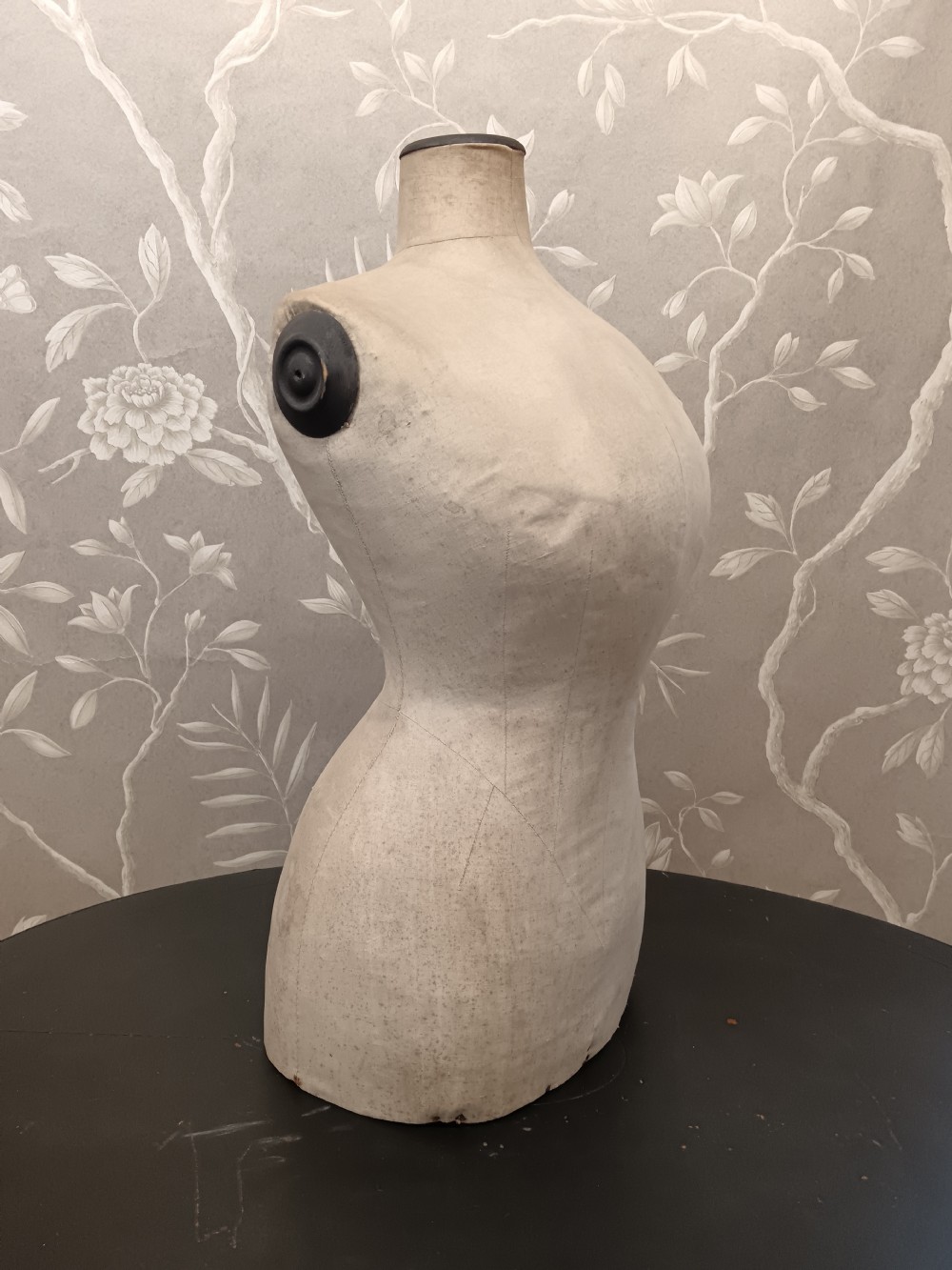 An aged cream fabric-covered female dressmaker torso mannequin bust with dark wood neck and shoulder caps. View VIII