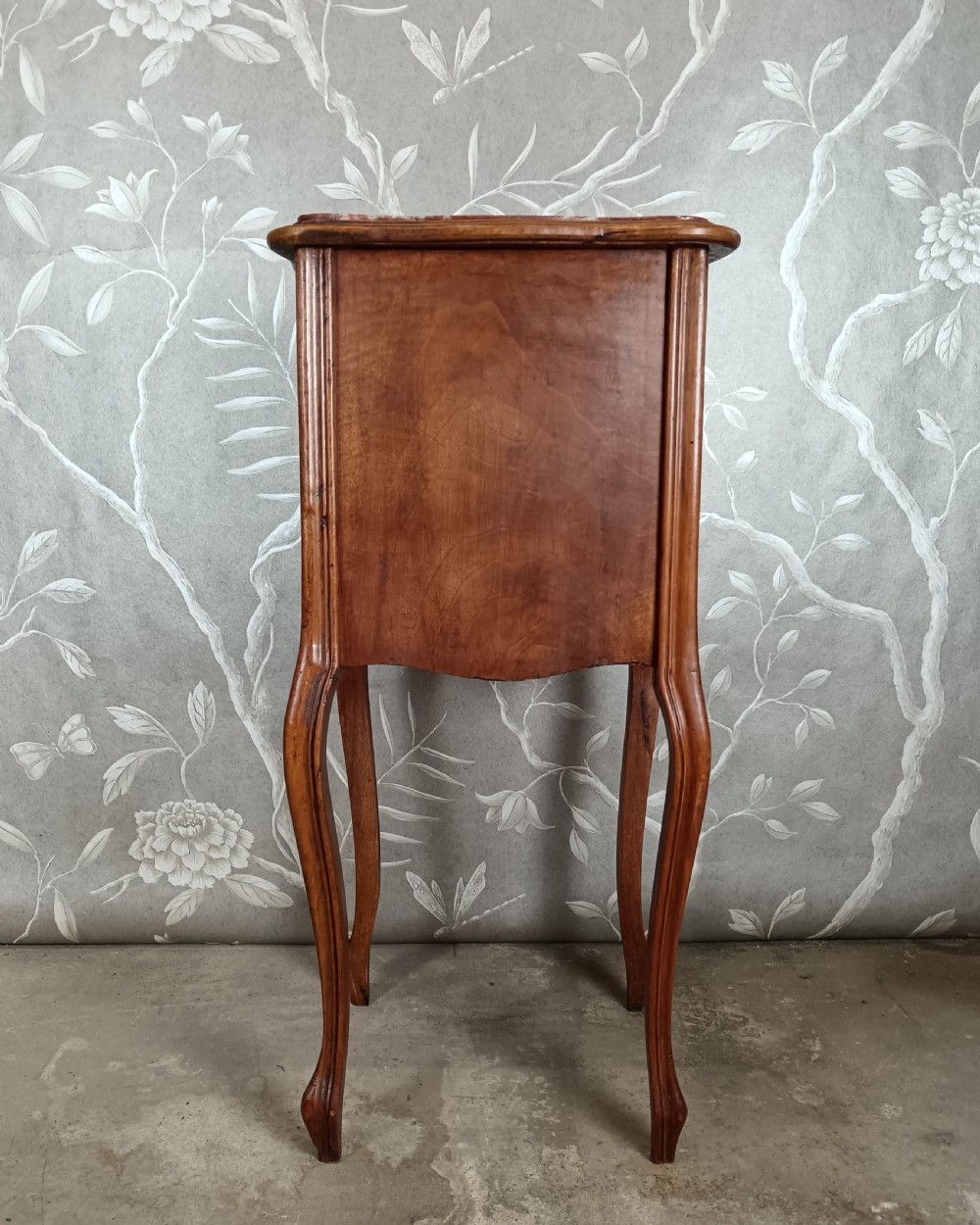 A tall French bedside cupboard crafted from warm brown wood with slim cabriole legs, parquetry panels, a single top drawer, and a lower cabinet door. View V