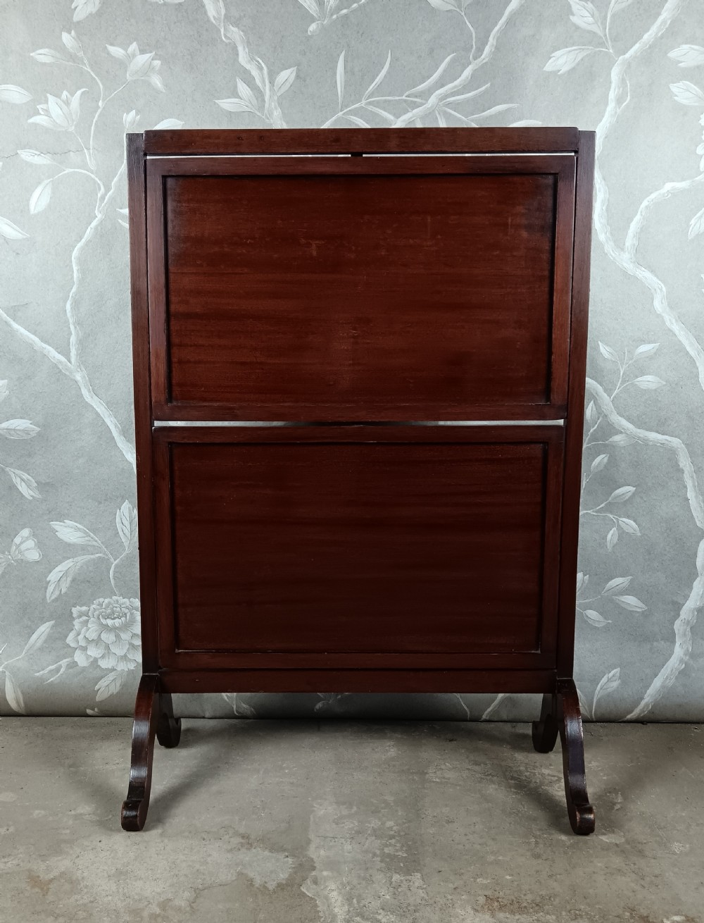 A dark mahogany two-tier folding dumb waiter with rectangular tray surfaces, upper carrying handle, and splayed legs. View III