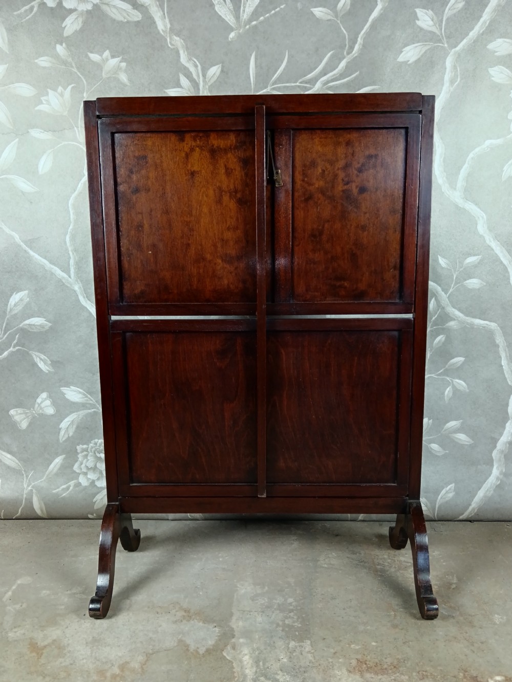A dark mahogany two-tier folding dumb waiter with rectangular tray surfaces, upper carrying handle, and splayed legs. View VI
