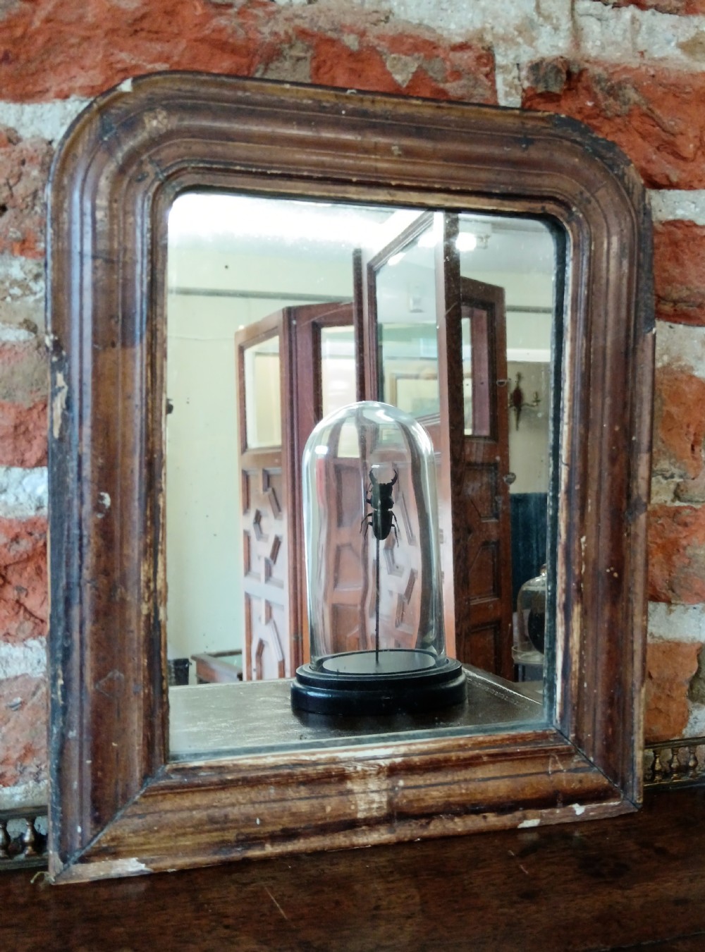 A petite 19th-century French Louis Philippe wall mirror featuring a moulded wooden frame with rounded upper corners and aged glass plate. View II