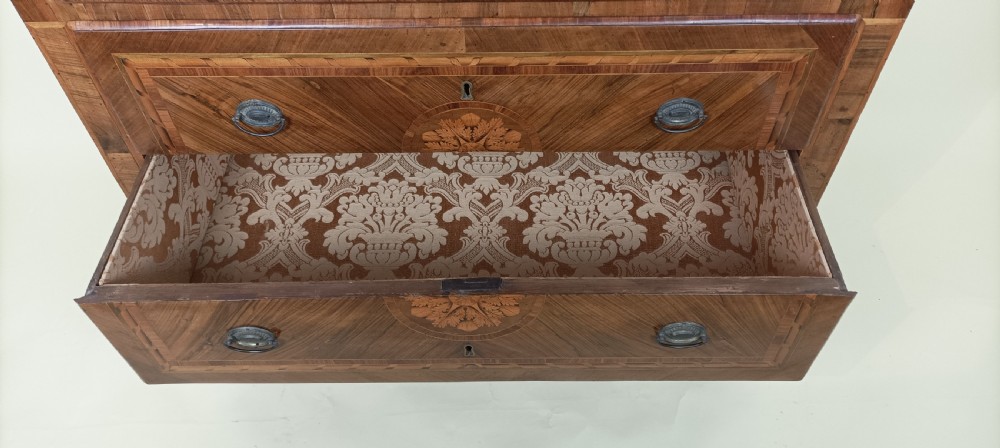 An eighteenth-century Italian Neoclassical marquetry commode with three drawers, geometric timber inlays, a grey marble top, and tapered square legs. View VIII