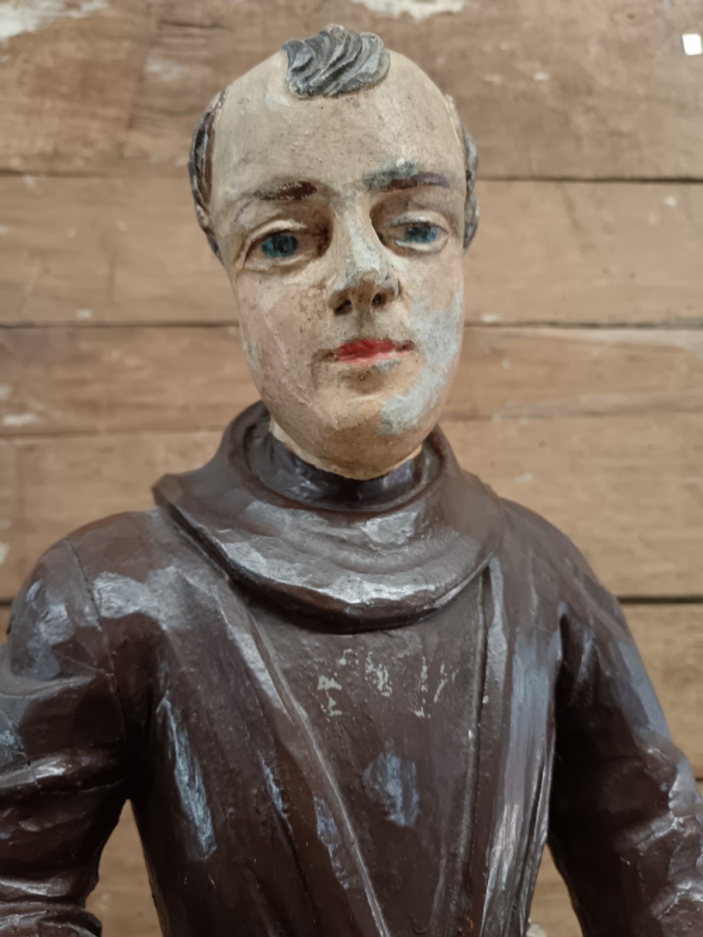 An antique carved wooden figure depicting Saint Anthony wearing a dark brown habit and holding a book. View VIII
