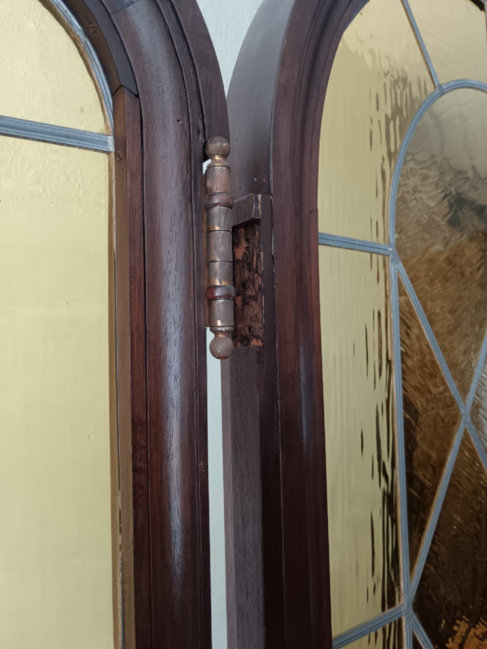 An antique dark wood vestibule doorway featuring a central arched leaded glass door flanked by two slender side lights and classic fluted columns. View XIV