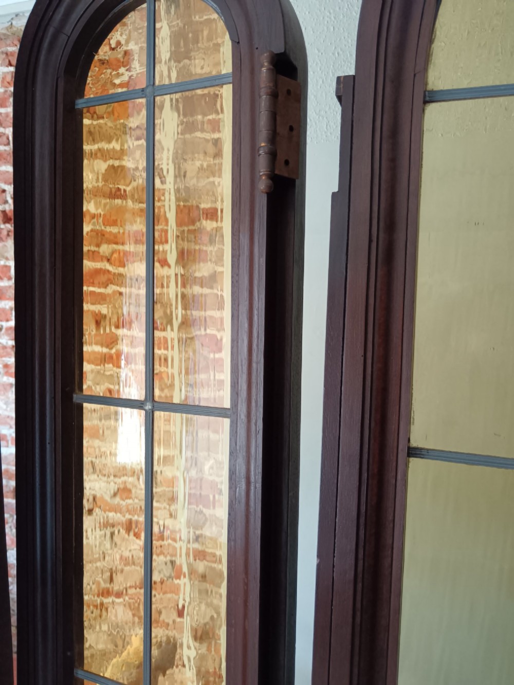 An antique dark wood vestibule doorway featuring a central arched leaded glass door flanked by two slender side lights and classic fluted columns. View XV