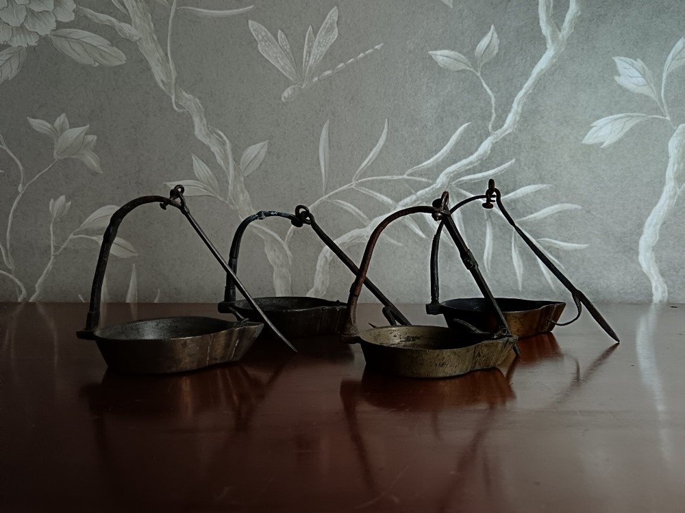 A collection of four antique Italian cast brass and bronze hanging Lucerna oil lamps with vertical suspension hooks and open oil reservoirs. View II