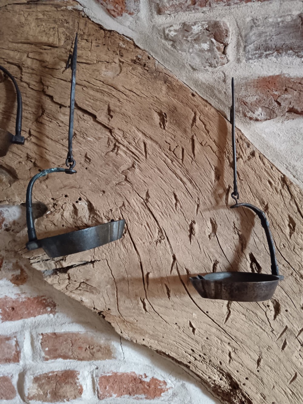 A collection of four antique Italian cast brass and bronze hanging Lucerna oil lamps with vertical suspension hooks and open oil reservoirs. View V