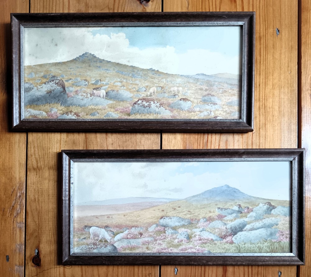 A pair of framed Edwardian watercolour paintings depicting rocky British moorland landscapes with grazing sheep under cloudy skies.