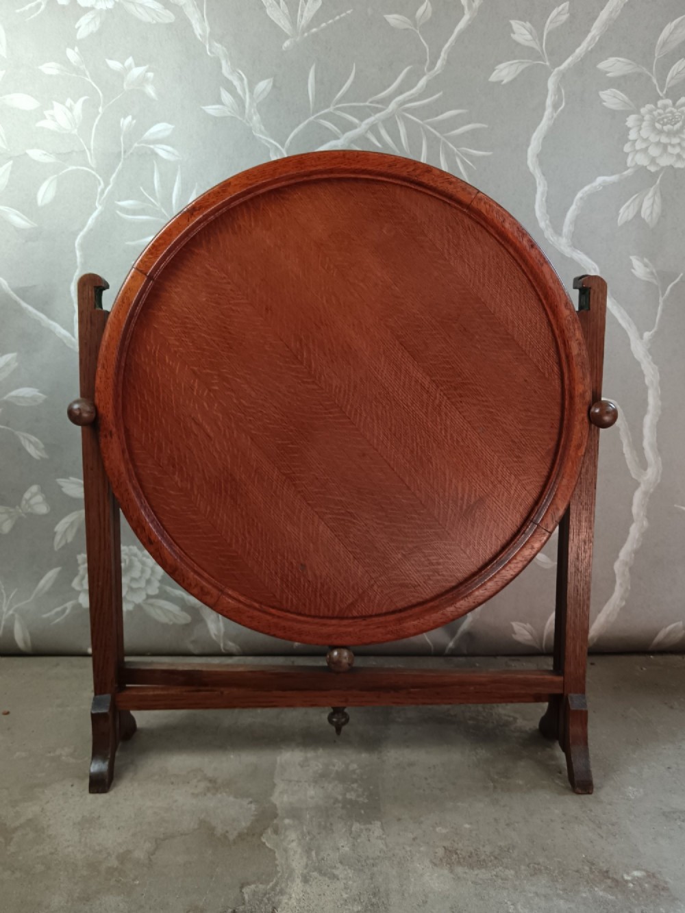 An antique oak folding card table with a circular reversible top supported by an interlocking wooden base. View IV