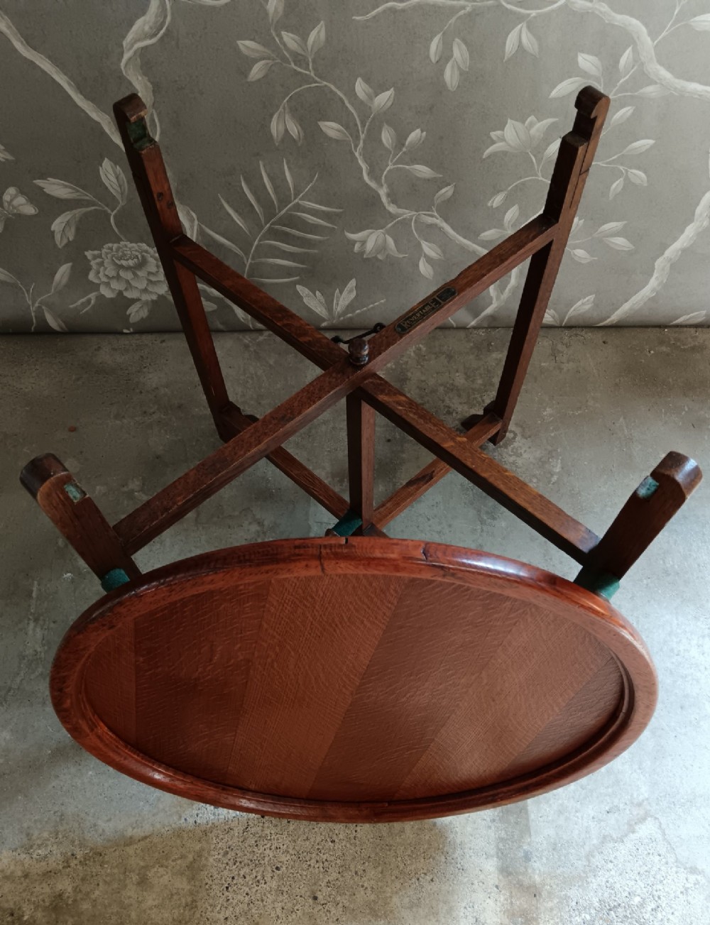 An antique oak folding card table with a circular reversible top supported by an interlocking wooden base. View XII