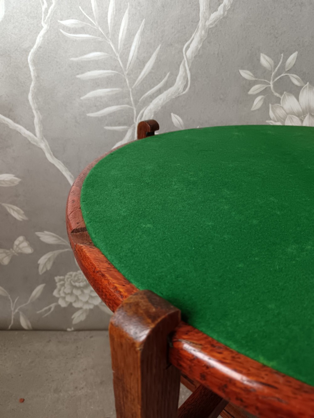 An antique oak folding card table with a circular reversible top supported by an interlocking wooden base. View XIII