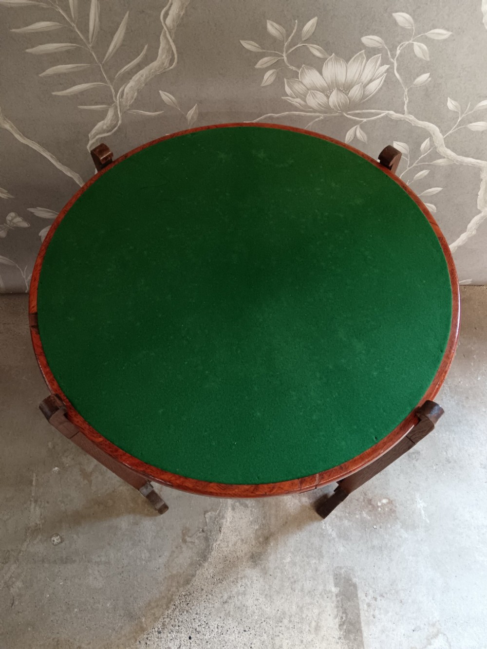 An antique oak folding card table with a circular reversible top supported by an interlocking wooden base. View XIV