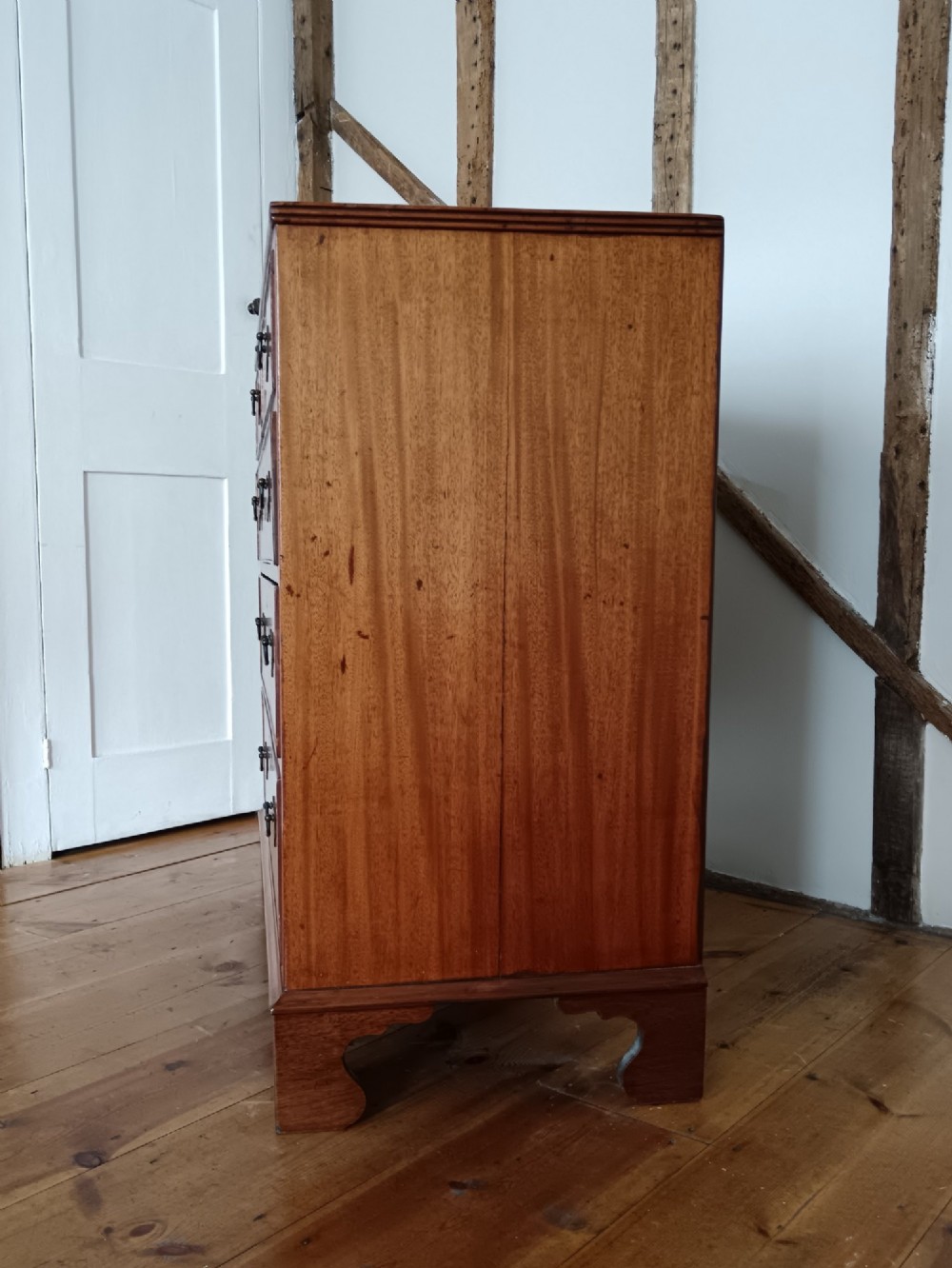 A Georgian mahogany chest of drawers featuring two short drawers above three full-width graduated drawers with brass drop handles and bracket feet. View III