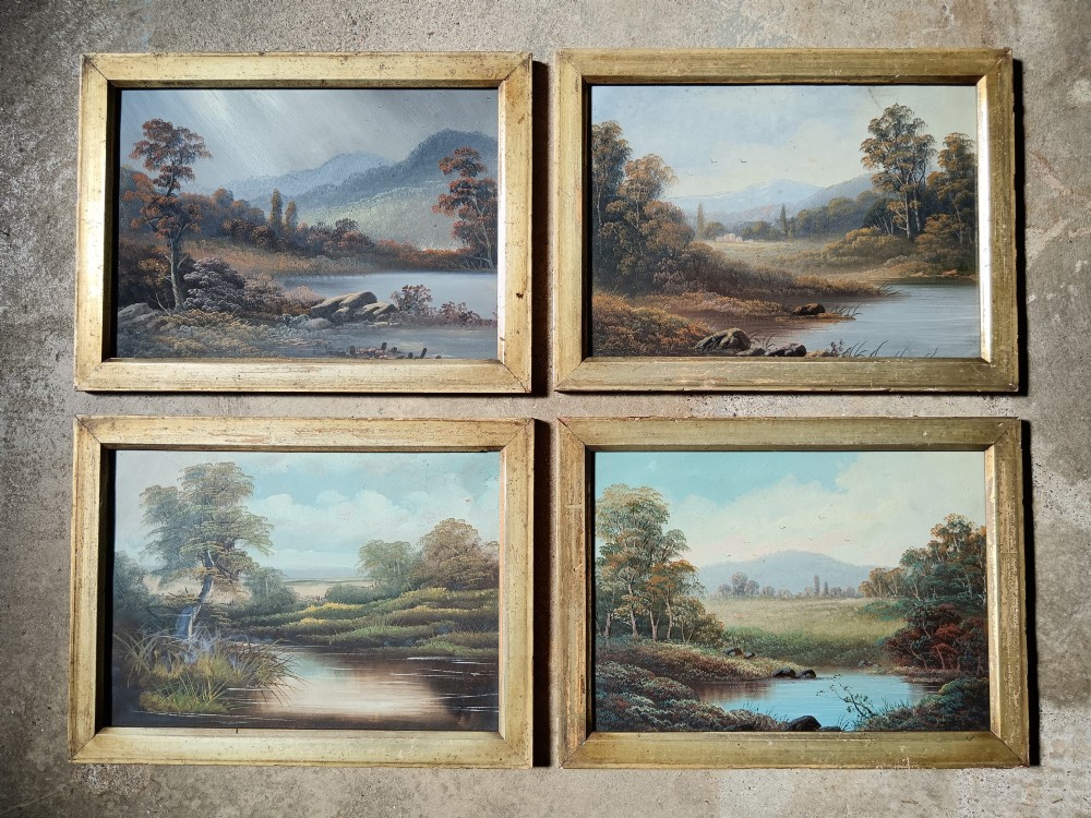 A set of four early 20th-century framed landscape paintings depicting river and woodland scenes set inside matching rectangular gilt frames.