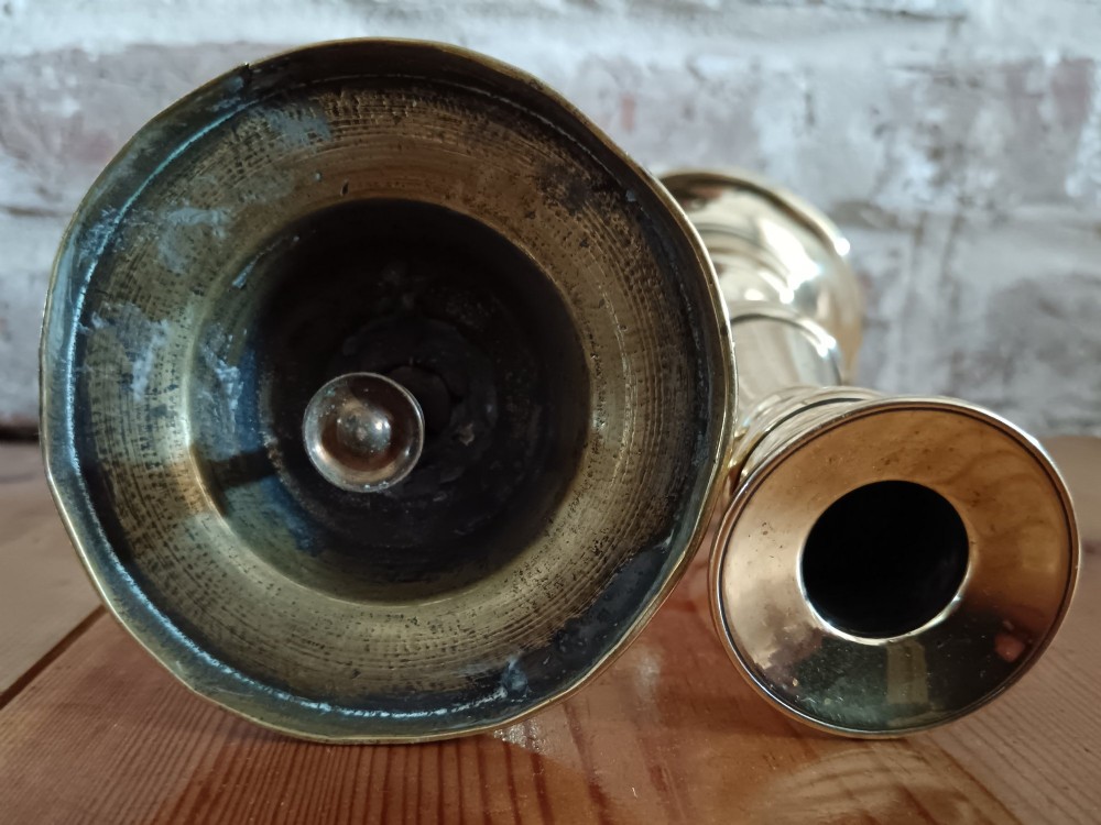 A pair of polished turned brass candlesticks featuring circular stepped bases and baluster stems. View IX