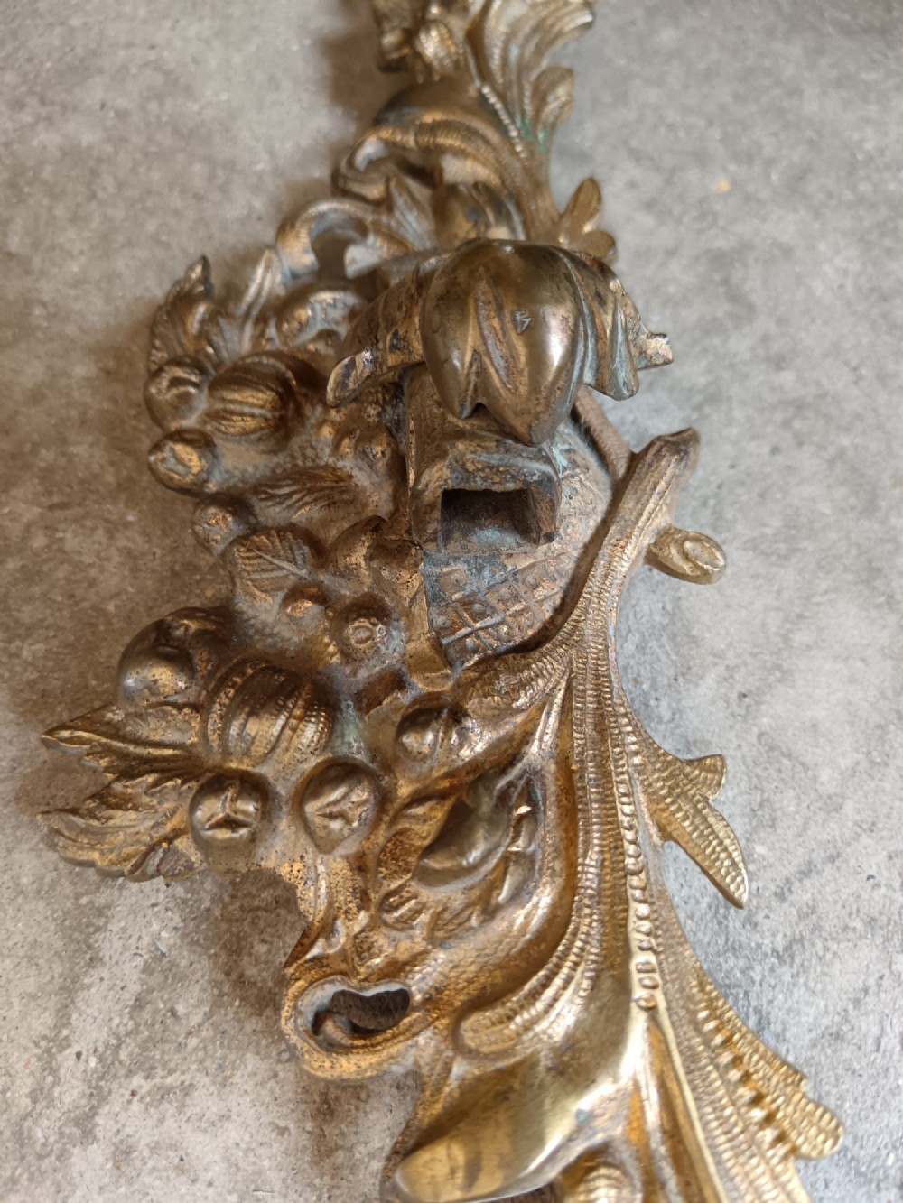 An oval gilt bronze wall mirror with a detailed floral foliate frame and a ribbon bow cresting at the top. View VIII