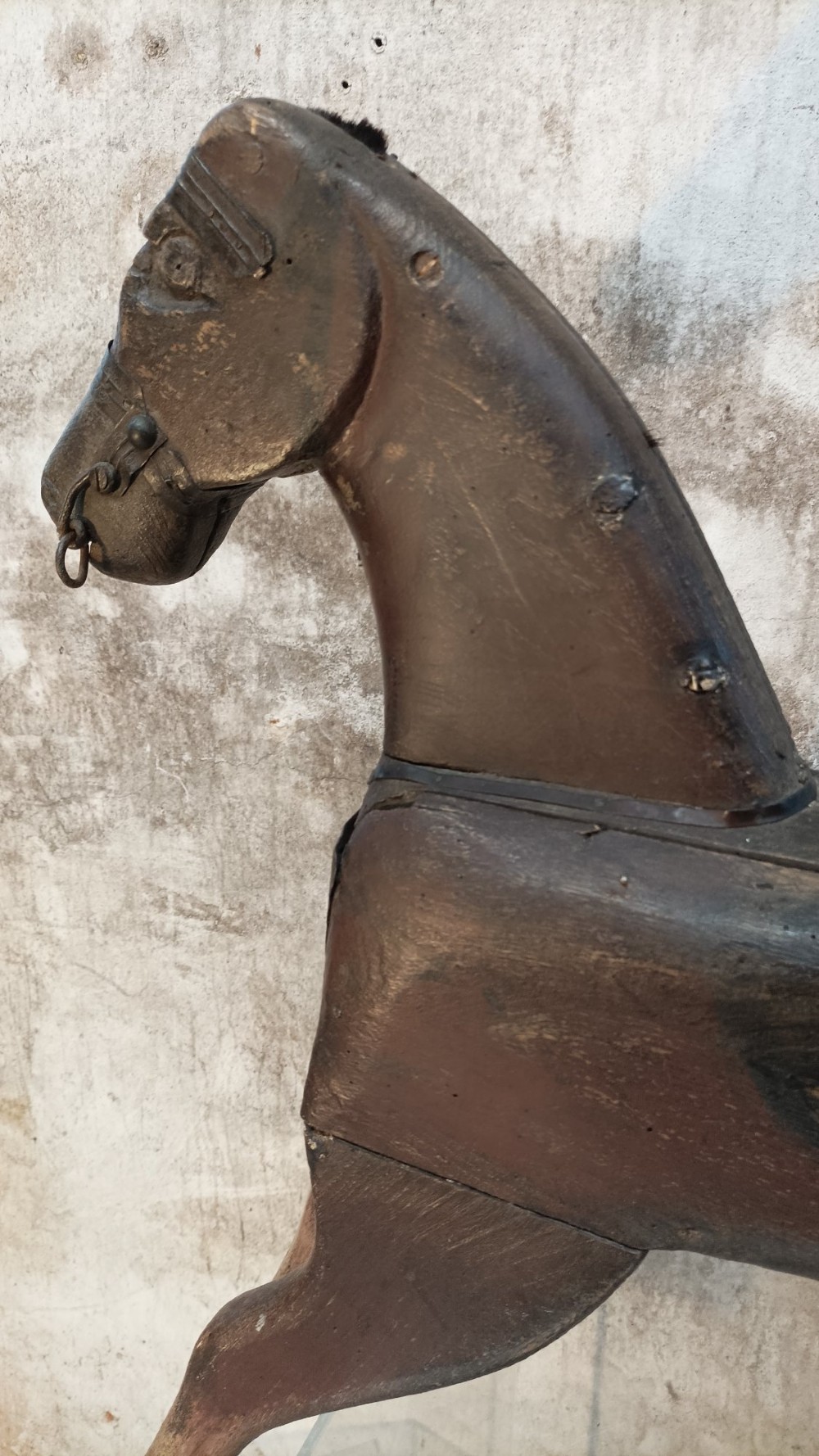 A hand-carved primitive wooden horse sculpture with a dark brown painted surface. View V