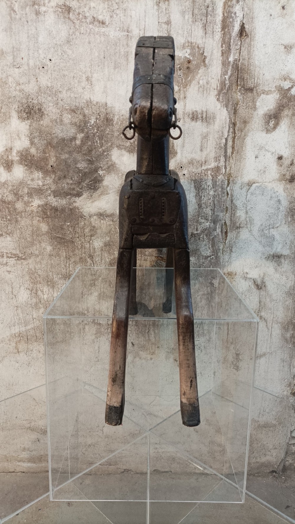 A hand-carved primitive wooden horse sculpture with a dark brown painted surface. View VII