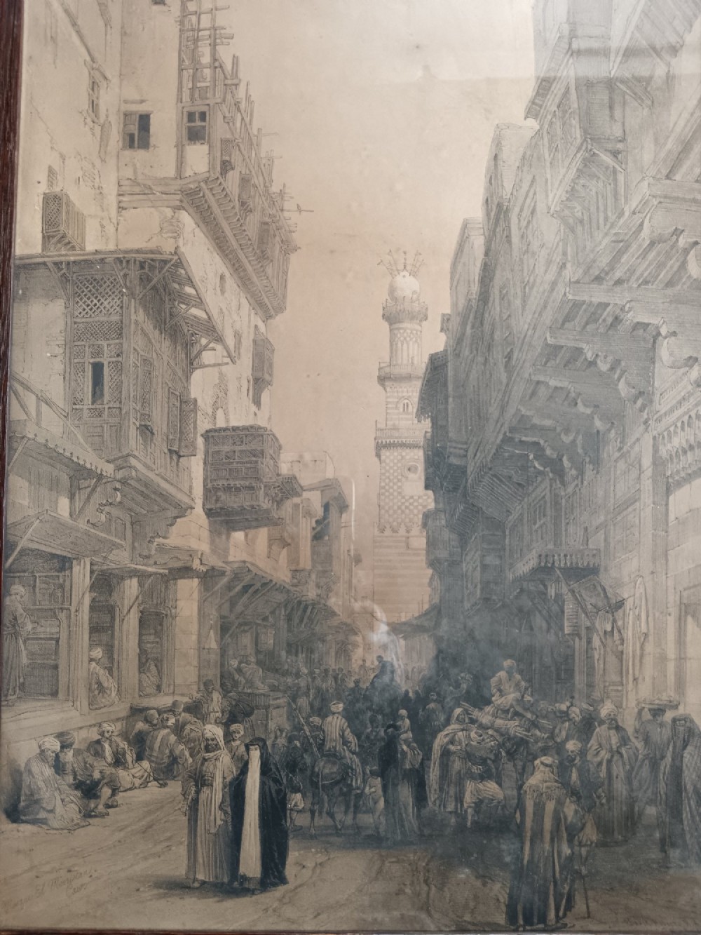 A pair of 19th-century sepia lithographs depicting architectural street and interior scenes of Cairo, mounted in dark oak frames. View V