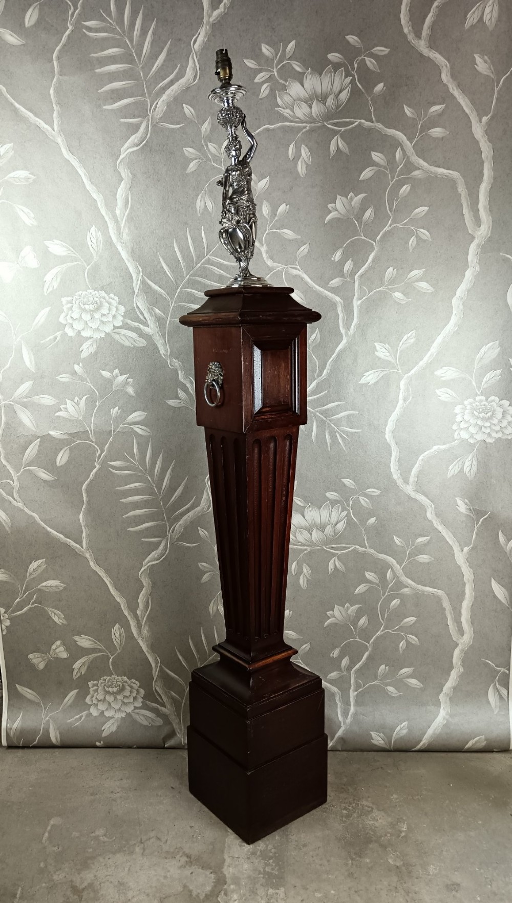 A dark wood tapered fluted pedestal column topped with a silver-plated classical female figural lamp fixture. View II