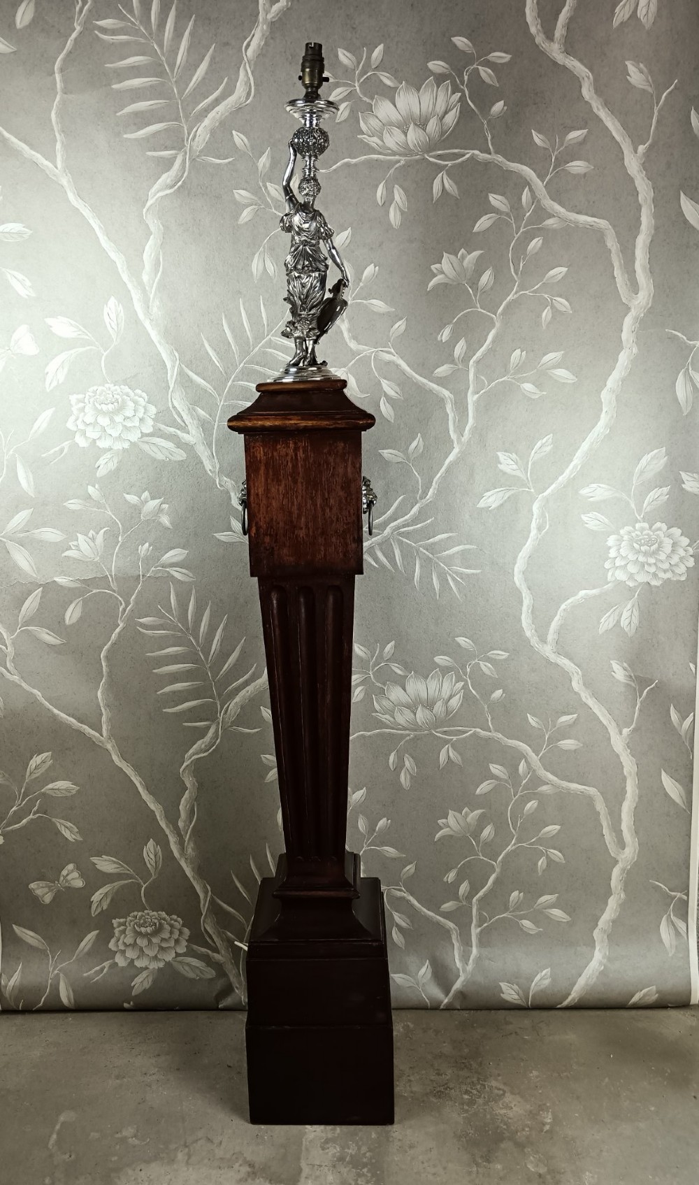 A dark wood tapered fluted pedestal column topped with a silver-plated classical female figural lamp fixture. View IV