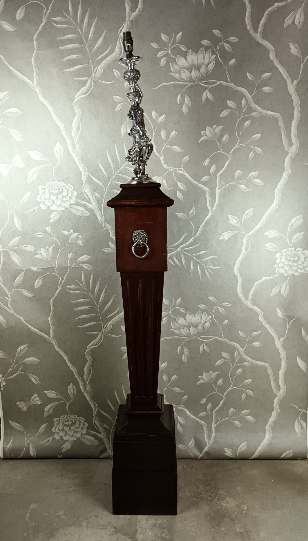 A dark wood tapered fluted pedestal column topped with a silver-plated classical female figural lamp fixture. View V