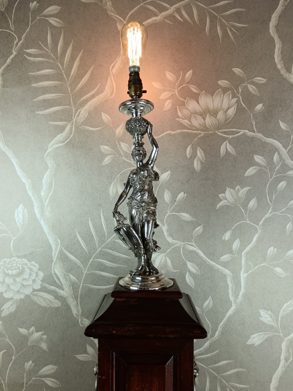 A dark wood tapered fluted pedestal column topped with a silver-plated classical female figural lamp fixture. View VII
