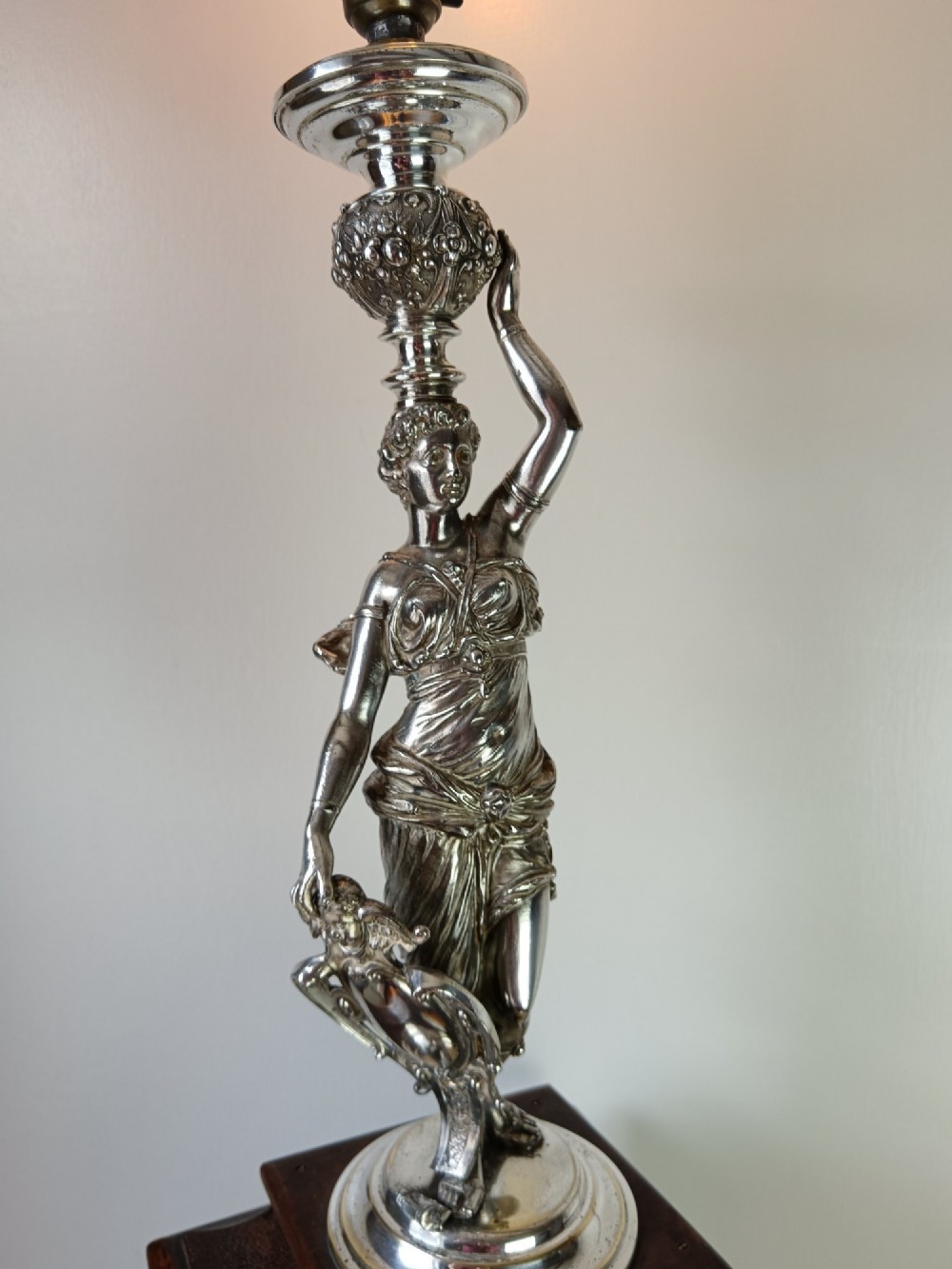 A dark wood tapered fluted pedestal column topped with a silver-plated classical female figural lamp fixture. View VIII