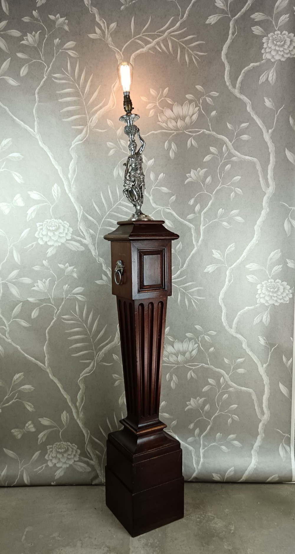 A dark wood tapered fluted pedestal column topped with a silver-plated classical female figural lamp fixture. View XIV