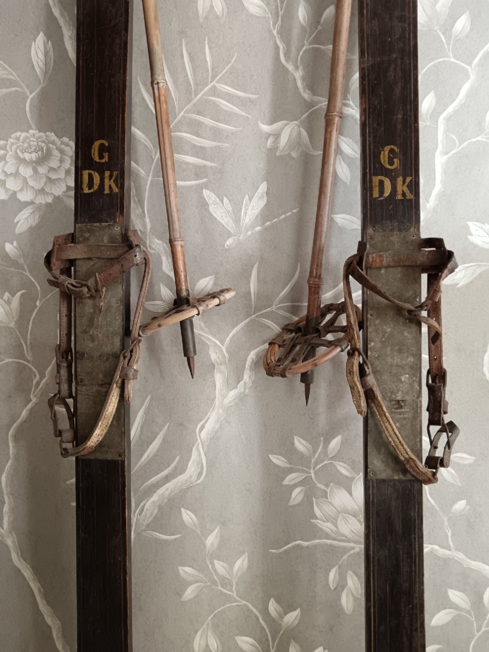 A pair of dark wood turn-of-the-century Norwegian skis accompanied by bamboo ski poles with leather bindings and cane baskets. View VIII