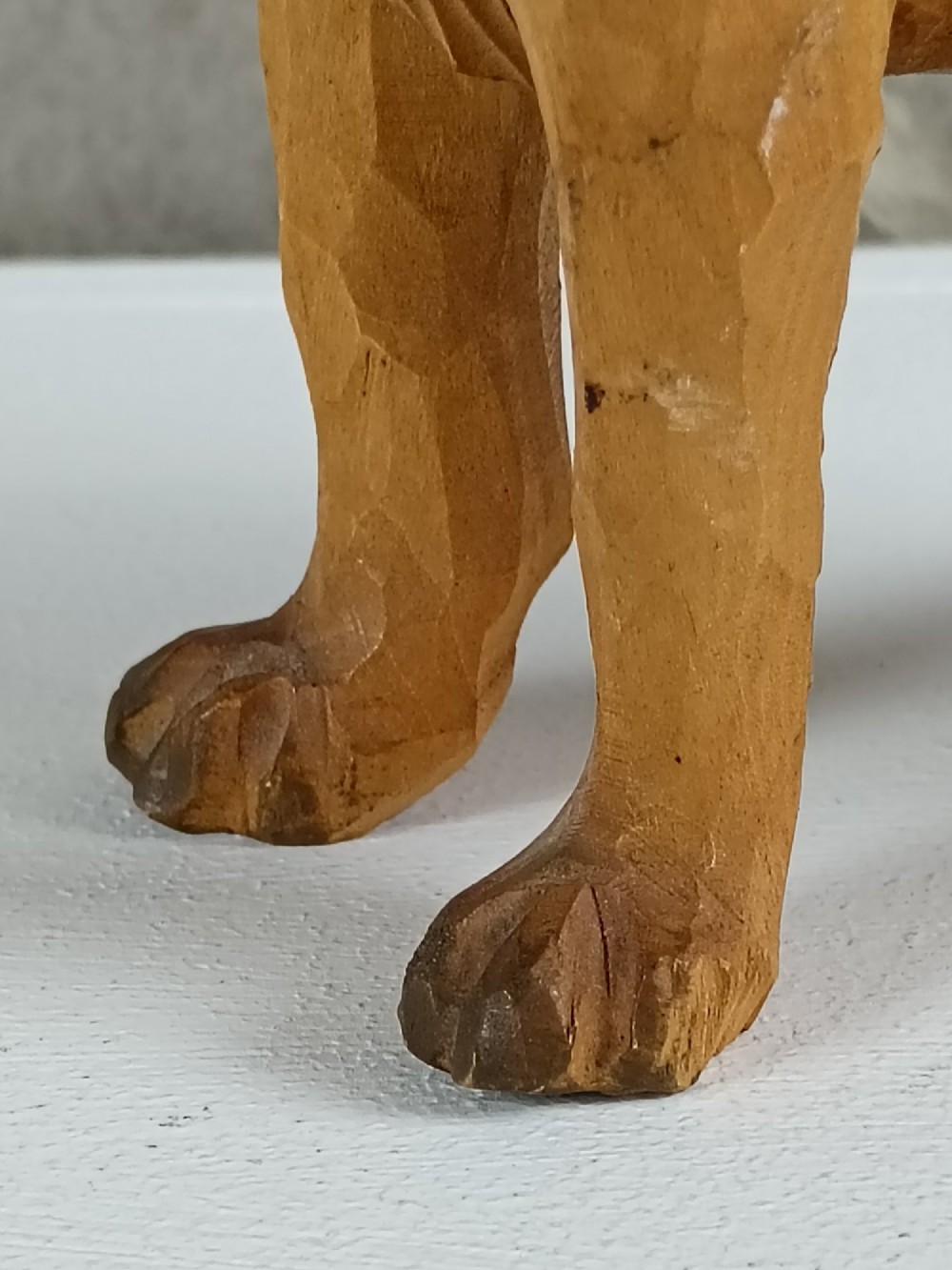 A carved and painted wooden sculpture of a standing Saint Bernard dog wearing a barrel around its neck. View V