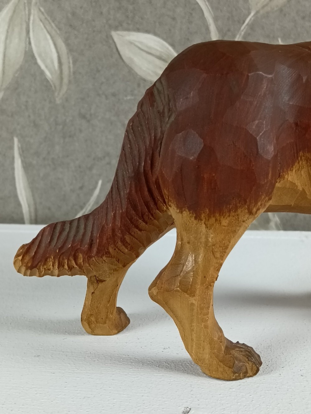 A carved and painted wooden sculpture of a standing Saint Bernard dog wearing a barrel around its neck. View VII