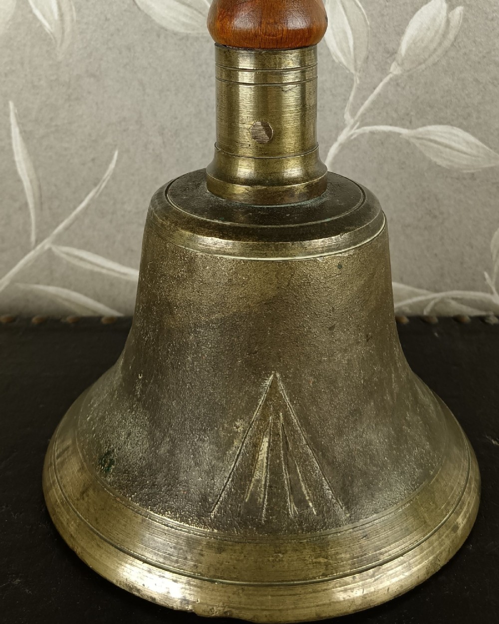 A cast brass military handbell featuring an engraved broad arrow mark and a turned dark wood handle. View II