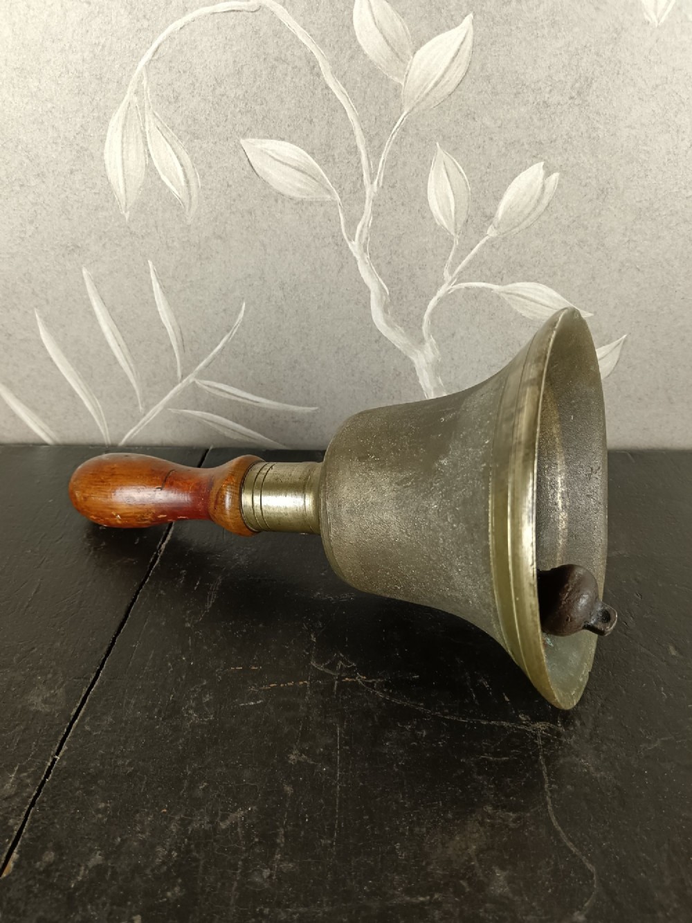 A cast brass military handbell featuring an engraved broad arrow mark and a turned dark wood handle. View III