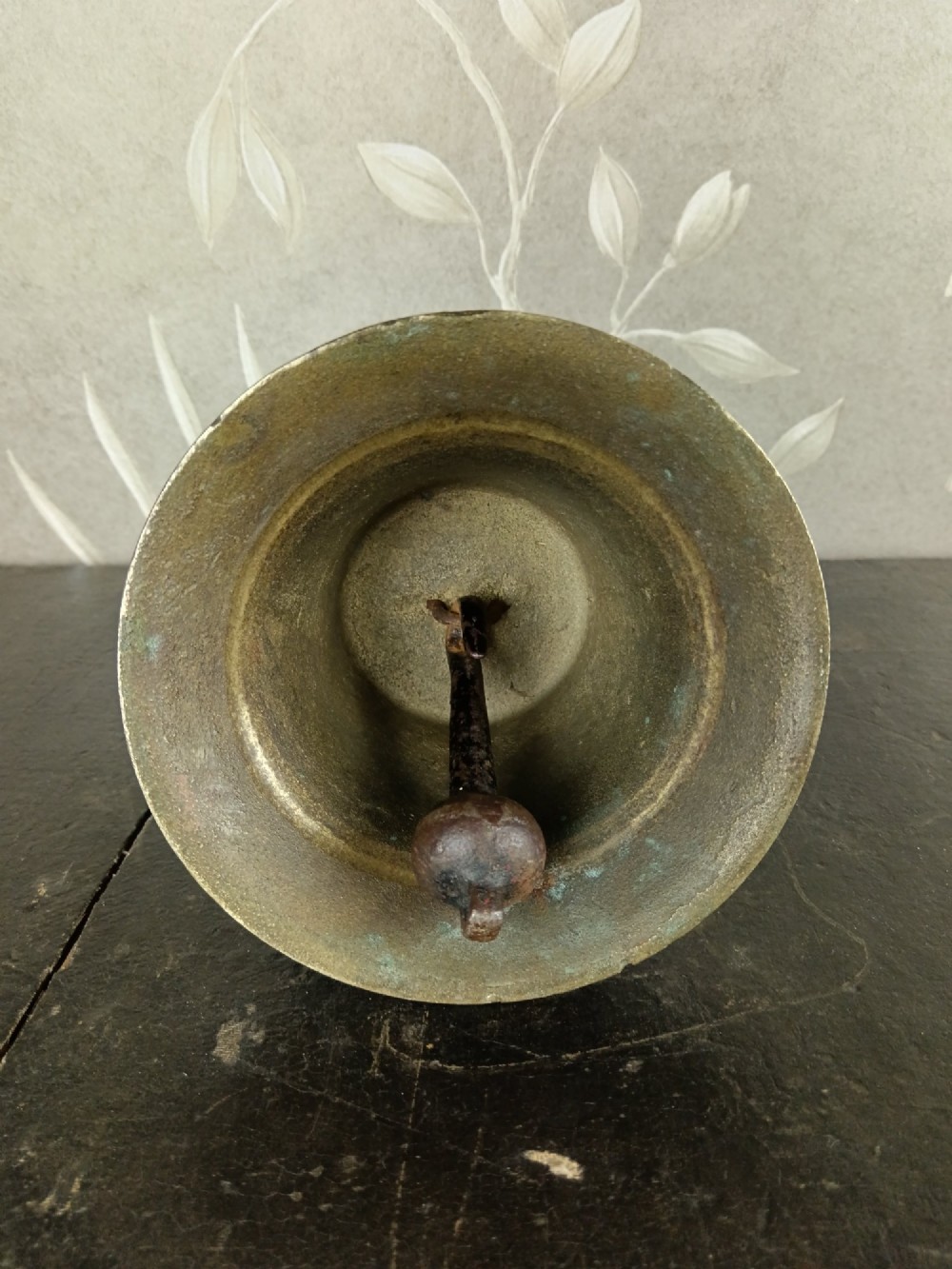 A cast brass military handbell featuring an engraved broad arrow mark and a turned dark wood handle. View V