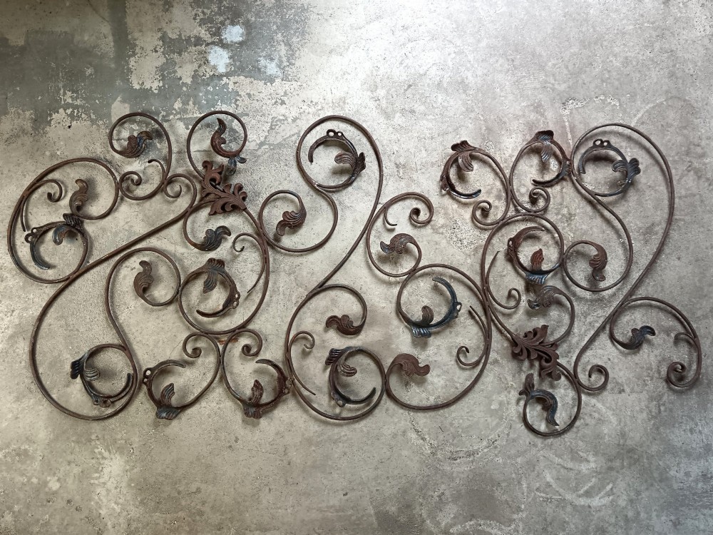 A pair of weathered wrought iron scroll panels featuring detailed acanthus leaves and a naturally oxidized brown finish. View V