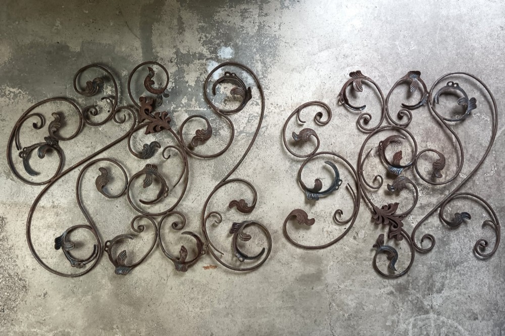 A pair of weathered wrought iron scroll panels featuring detailed acanthus leaves and a naturally oxidized brown finish. View VII