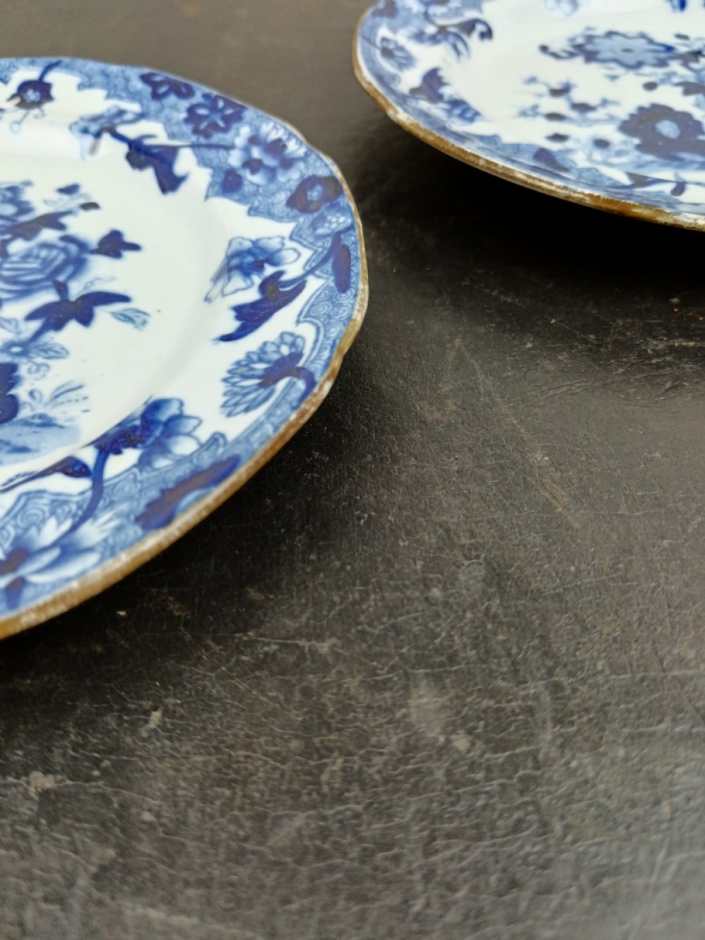 A pair of circular Georgian ceramic tea plates featuring blue and white floral underglaze decoration with scalloped edges. View IX