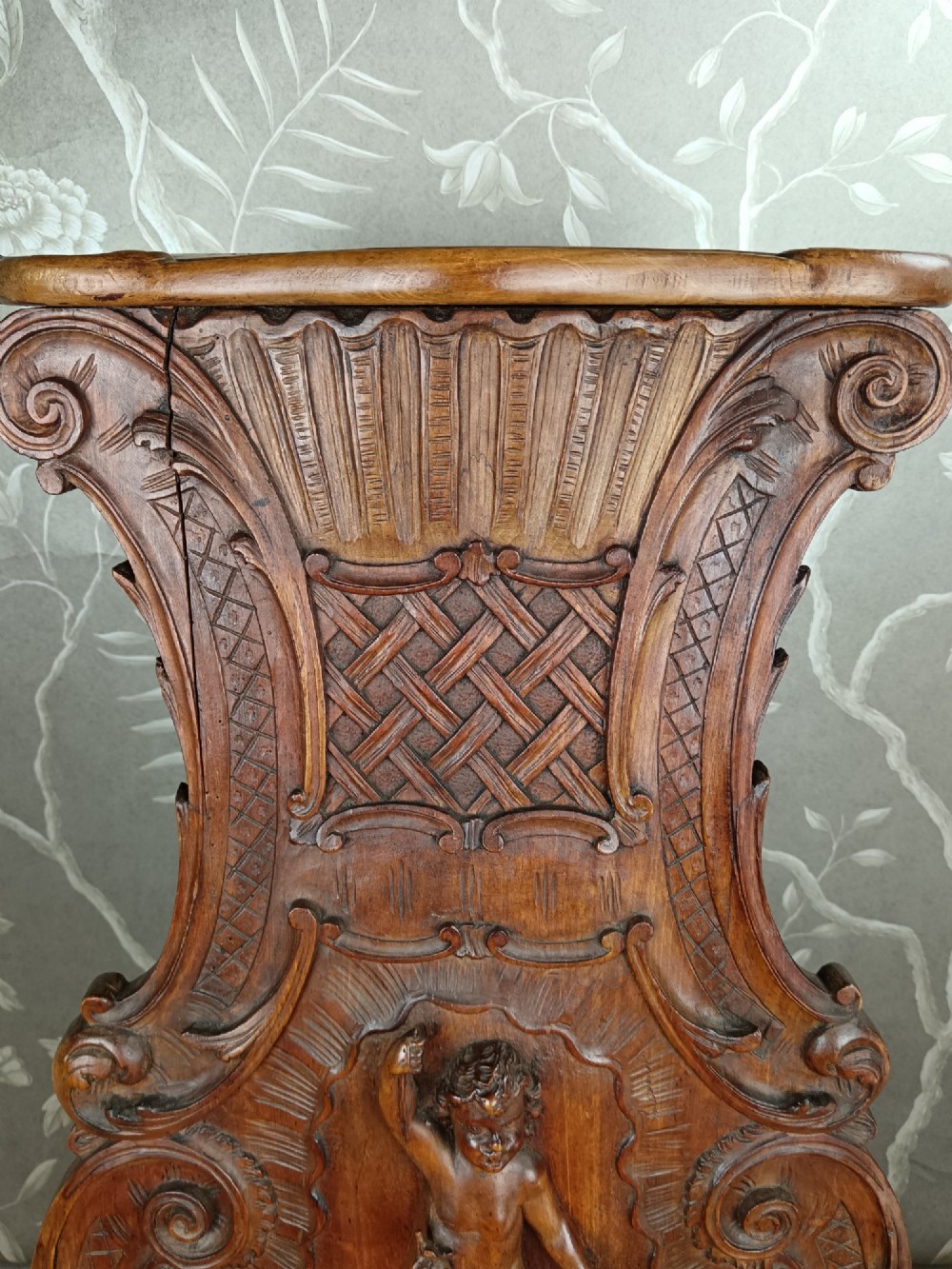 A 19th-century Italian carved walnut pedestal stand featuring a central relief carving of a cherub, acanthus scrollwork, and lattice detailing. View III